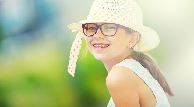 image of girl with braces wear a hat and smiling